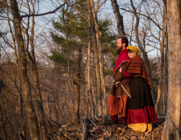 A viking larp couple stand together in the woods during sunset during their Harpers Ferry Engagement photos