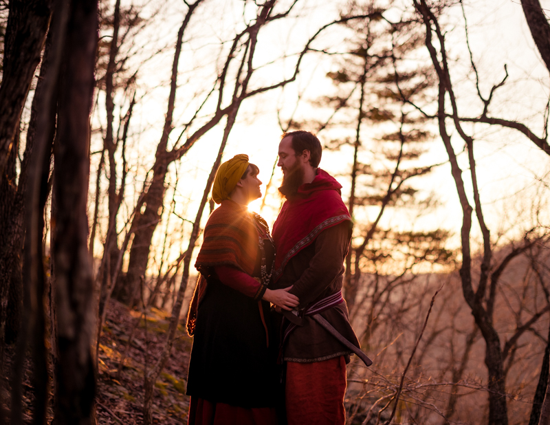 A viking larp couple is poses against the setting sun during their Harpers Ferry engagement photos